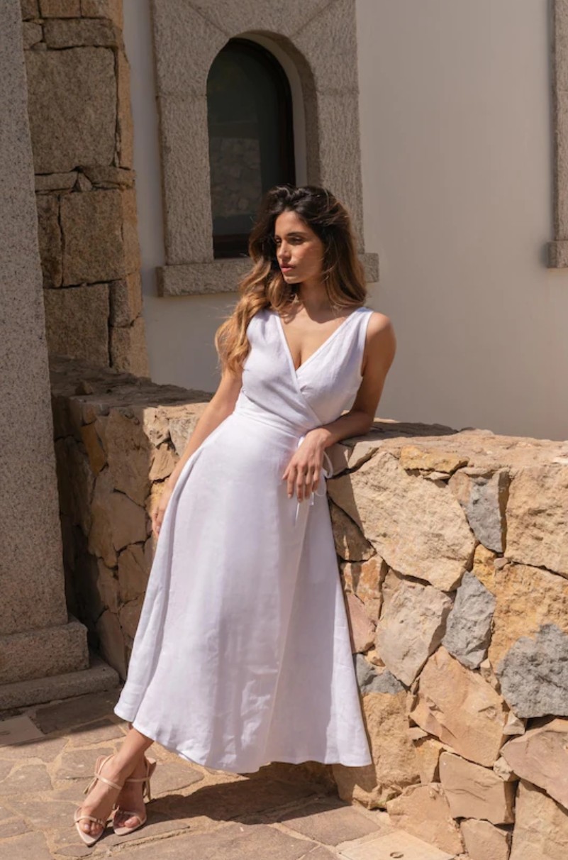 Taş duvar önünde sarma model beyaz elbise